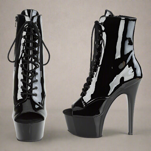 Black patent leather high-heeled platform boots on a white background