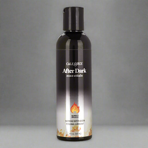 A black bottle of AFTER DARK WARMING LUBRICANT with a label showing the product name and a flame graphic, indicating a warming effect.