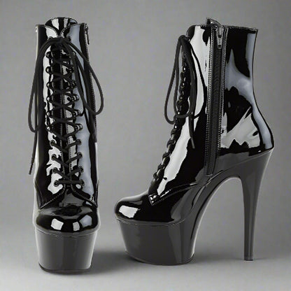 Black patent leather high-heeled boots on a white background