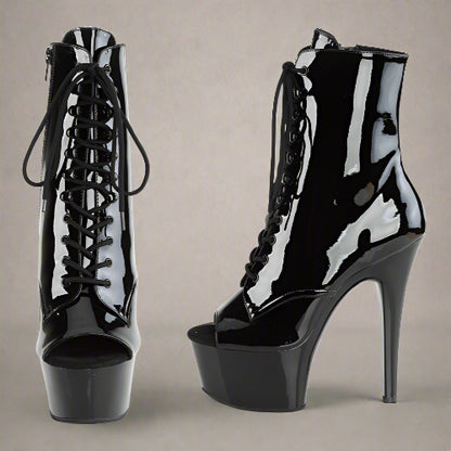 Black patent leather high-heeled platform boots on a white background