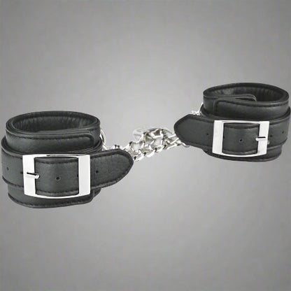 Black leather handcuffs with silver buckles on a white background