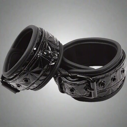 Black metal ring with intricate design on a white background