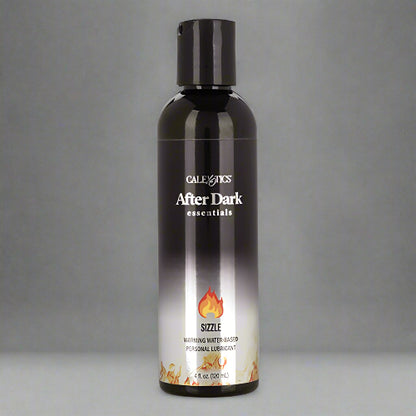 A black bottle of AFTER DARK WARMING LUBRICANT with a label showing the product name and a flame graphic, indicating a warming effect.